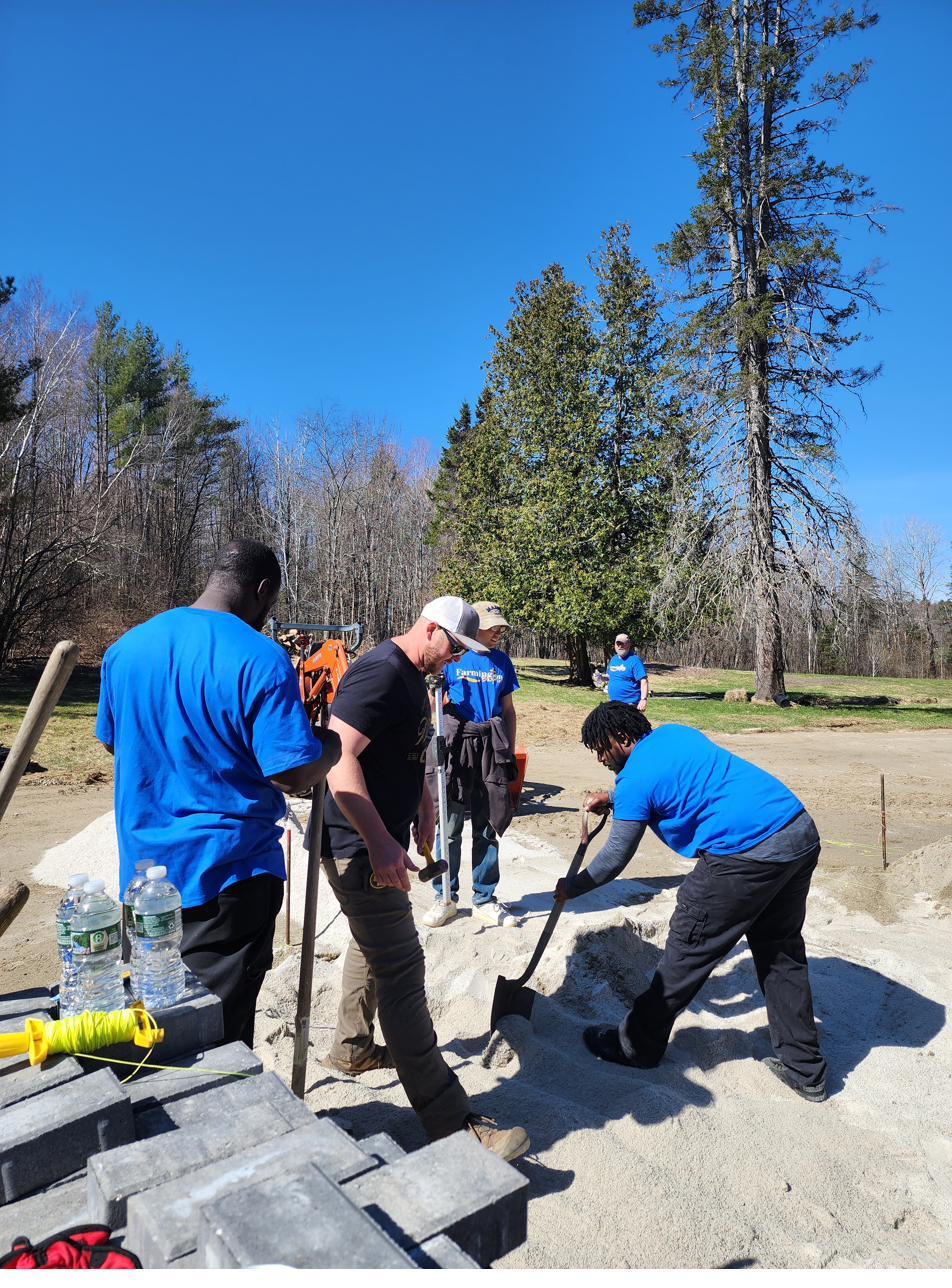 A crew laying paver stones at the Whittier Road campus on a clear day.