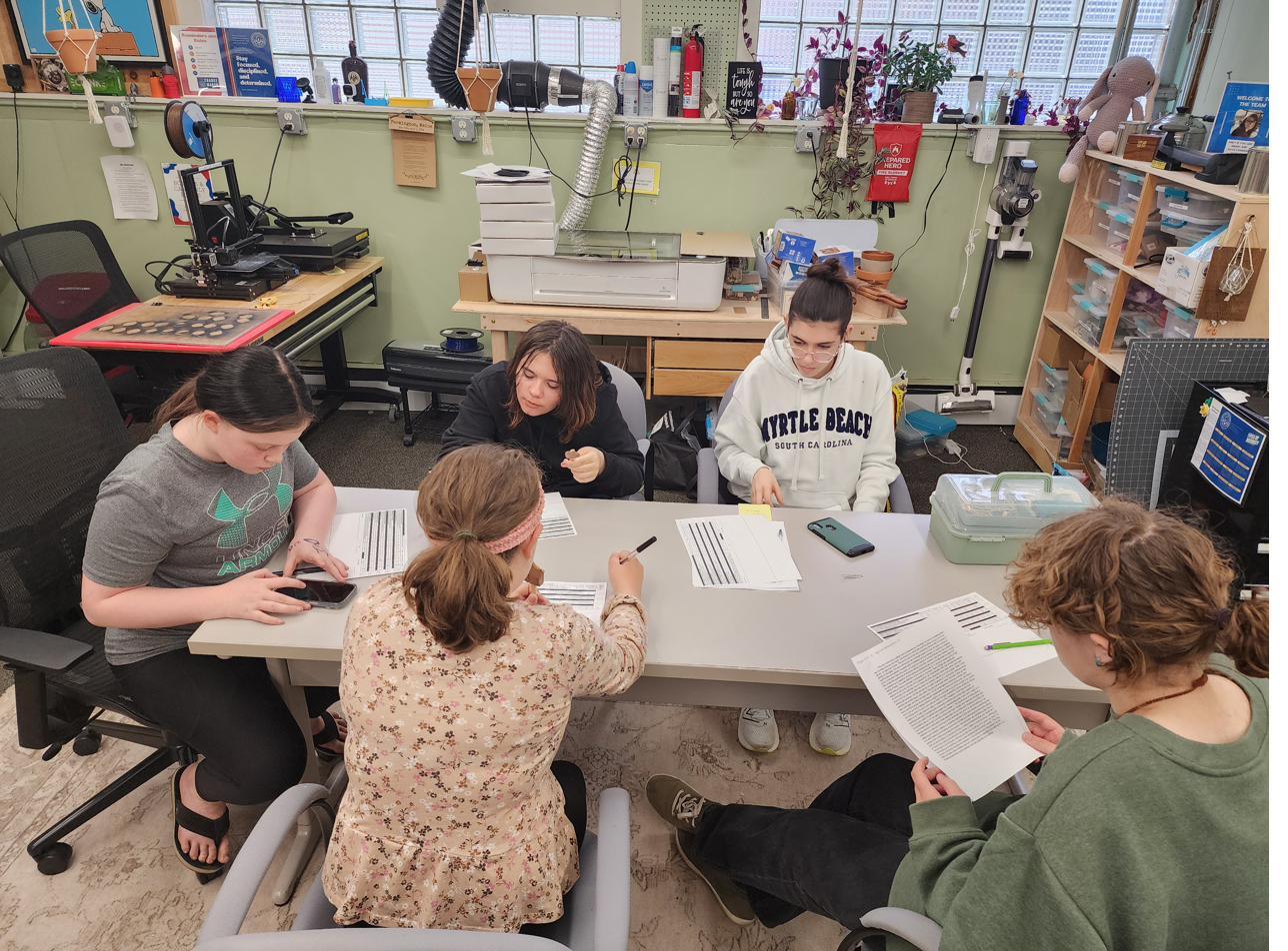 A CES cohort session around a table in the makerspace.