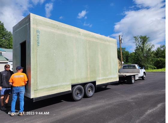 The tiny home shell arriving on a trailer.